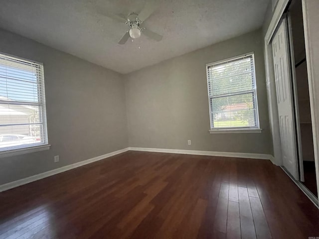 101 Chula Vista Rd, El Dorado Springs, AR 71730 - unfurnished bedroom with dark wood finished floors, multiple windows, baseboards, and a closet