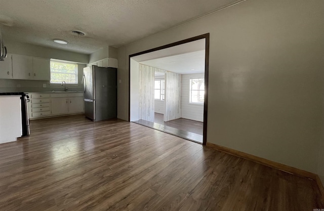 101 Chula Vista Rd, El Dorado Springs, AR 71730 - kitchen with freestanding refrigerator, a sink, dark wood finished floors, white cabinets, and a textured ceiling