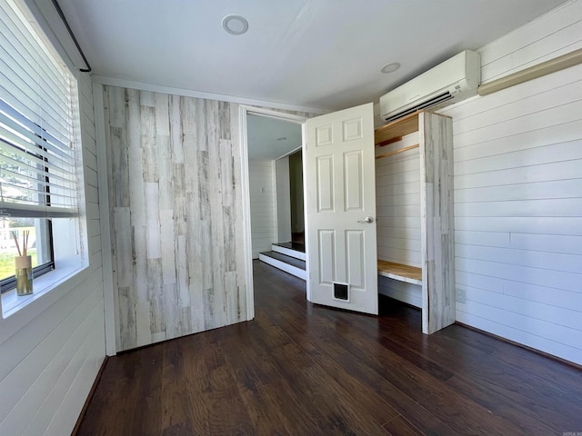 101 Chula Vista Rd, El Dorado Springs, AR 71730 - empty room featuring an AC wall unit, wooden walls, and dark wood-type flooring