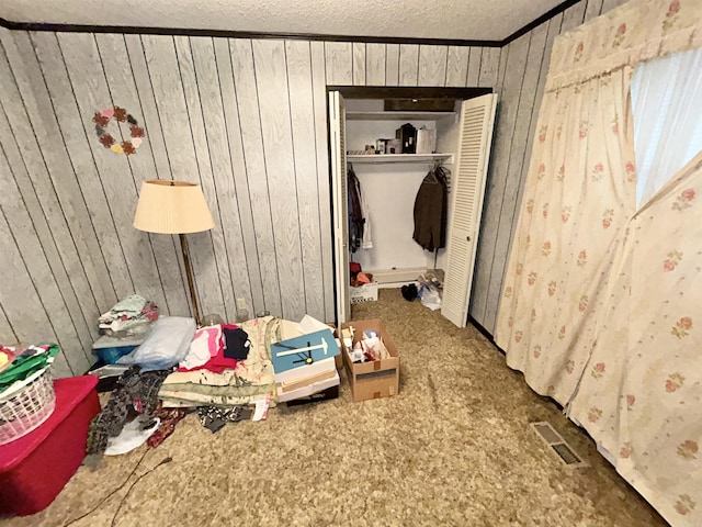 4109 Garrison Rd, Little Rock, AR 72223 - bedroom with a textured ceiling, wooden walls, ornamental molding, and a closet