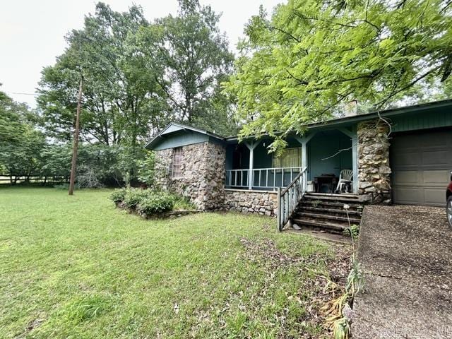 4109 Garrison Rd, Little Rock, AR 72223 - view of property exterior featuring stone siding, a lawn, an attached garage, and a porch