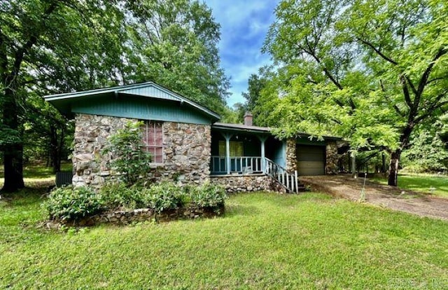 4109 Garrison Rd, Little Rock, AR 72223 - view of side of home featuring stone siding, a garage, concrete driveway, a yard, and covered porch