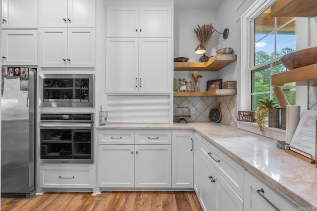 2995 Cresthaven St, Conway, AR 72034 - kitchen with open shelves, appliances with stainless steel finishes, white cabinets, and light stone counters