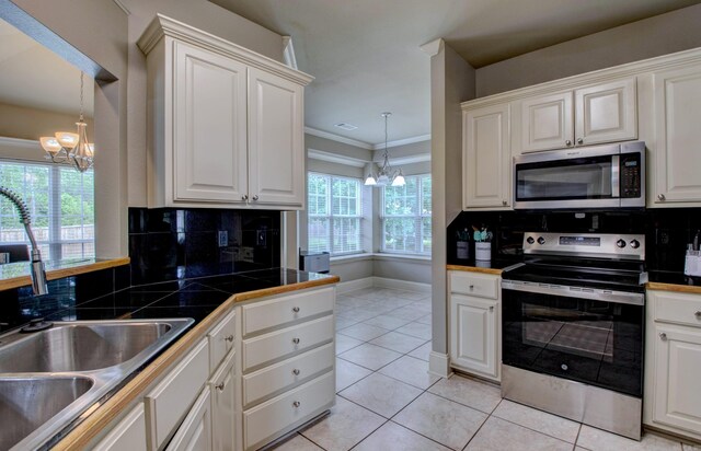 76 Woodridge Dr, Little Rock, AR 72204 - kitchen featuring stainless steel appliances, a chandelier, a sink, tasteful backsplash, and ornamental molding