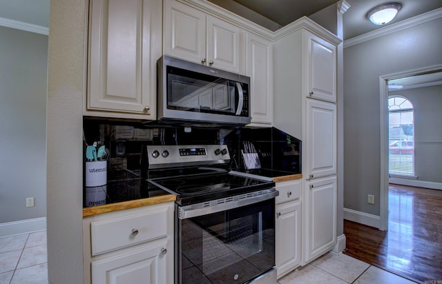 76 Woodridge Dr, Little Rock, AR 72204 - kitchen with appliances with stainless steel finishes, ornamental molding, tasteful backsplash, white cabinets, and baseboards