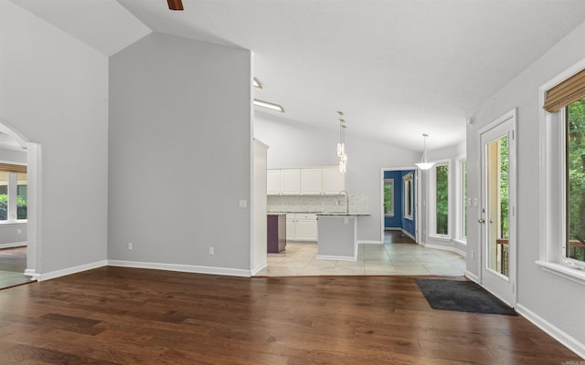 74 Medina Way, Hot Springs Village, AR 71909 - unfurnished living room featuring light wood-style floors, healthy amount of natural light, baseboards, high vaulted ceiling, and a ceiling fan