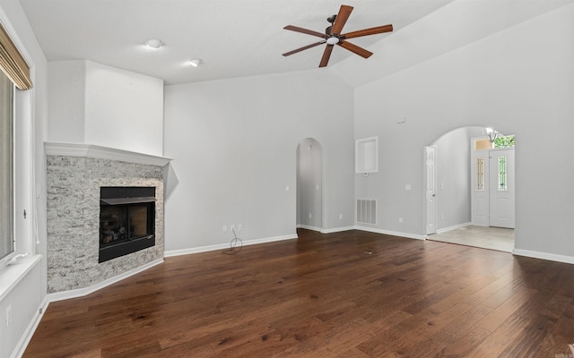 74 Medina Way, Hot Springs Village, AR 71909 - unfurnished living room with arched walkways, ceiling fan, high vaulted ceiling, a fireplace, and wood finished floors