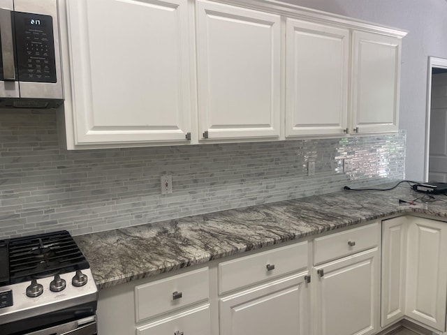 74 Medina Way, Hot Springs Village, AR 71909 - kitchen with appliances with stainless steel finishes, white cabinetry, tasteful backsplash, and stone counters