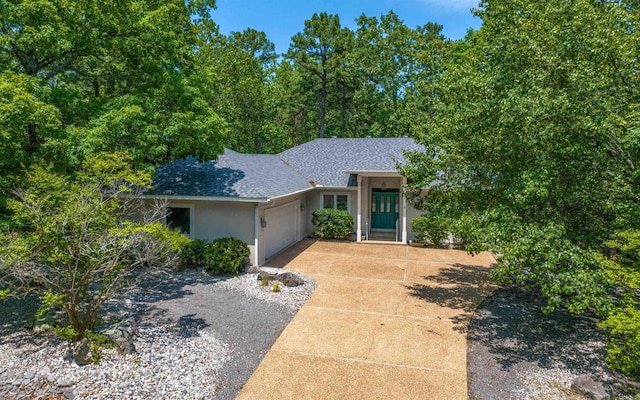 74 Medina Way, Hot Springs Village, AR 71909 - view of front facade with a garage, a shingled roof, stucco siding, and driveway