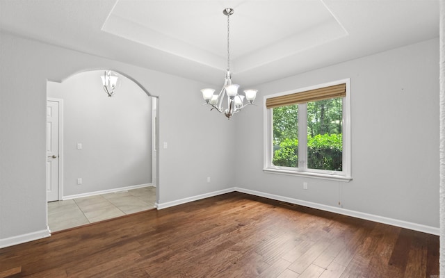 74 Medina Way, Hot Springs Village, AR 71909 - unfurnished room featuring a chandelier, hardwood / wood-style floors, arched walkways, a raised ceiling, and baseboards