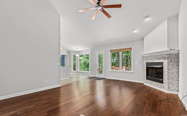 74 Medina Way, Hot Springs Village, AR 71909 - unfurnished living room with vaulted ceiling, a ceiling fan, baseboards, a tile fireplace, and wood finished floors