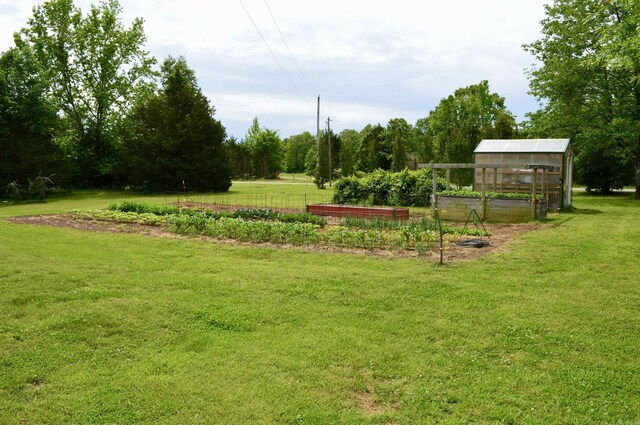 1005 Georgia Ridge Rd, Searcy, AR 72143 - view of green lawn featuring a vegetable garden, an exterior structure, and an outbuilding