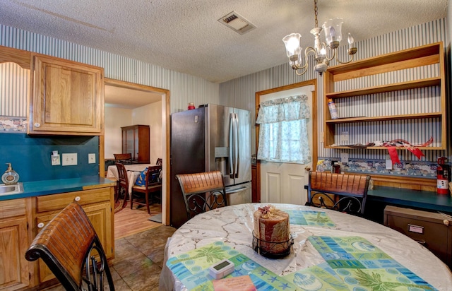 32 Bonnie Park Dr, Pine Bluff, AR 72601 - dining space featuring wallpapered walls, a textured ceiling, and a chandelier