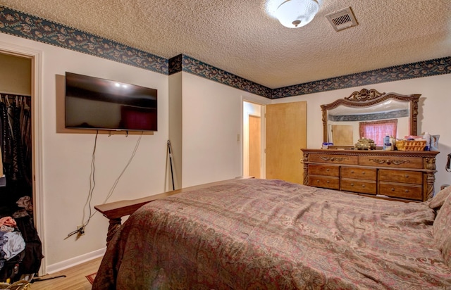 32 Bonnie Park Dr, Pine Bluff, AR 72601 - bedroom with a textured ceiling, wood finished floors, a spacious closet, a closet, and baseboards