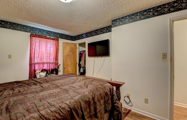 32 Bonnie Park Dr, Pine Bluff, AR 72601 - bedroom featuring wood finished floors, a textured ceiling, and baseboards