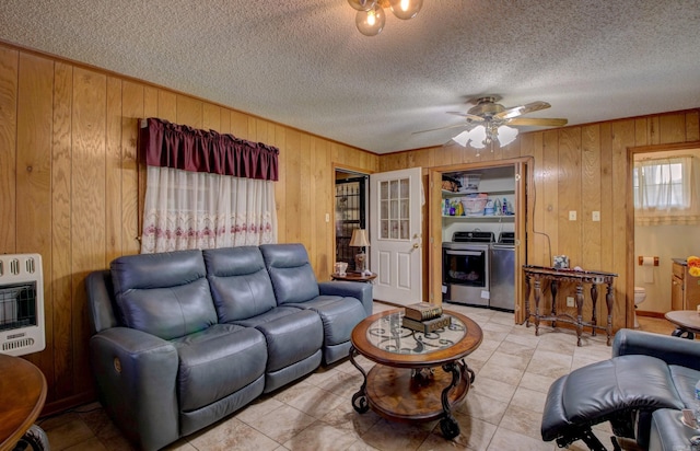 32 Bonnie Park Dr, Pine Bluff, AR 72601 - living area featuring heating unit, wood walls, a ceiling fan, light tile patterned floors, and a textured ceiling