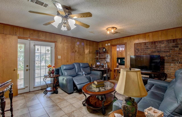 32 Bonnie Park Dr, Pine Bluff, AR 72601 - living room with wood walls, a textured ceiling, a ceiling fan, and light tile patterned floors