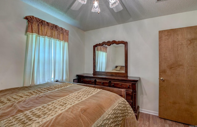 32 Bonnie Park Dr, Pine Bluff, AR 72601 - bedroom featuring light wood-style floors, ceiling fan, a textured ceiling, and baseboards