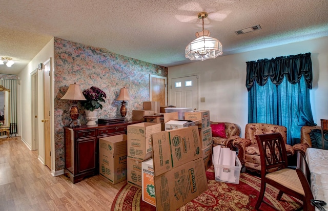 32 Bonnie Park Dr, Pine Bluff, AR 72601 - dining space with a textured ceiling, wallpapered walls, light wood finished floors, a chandelier, and baseboards