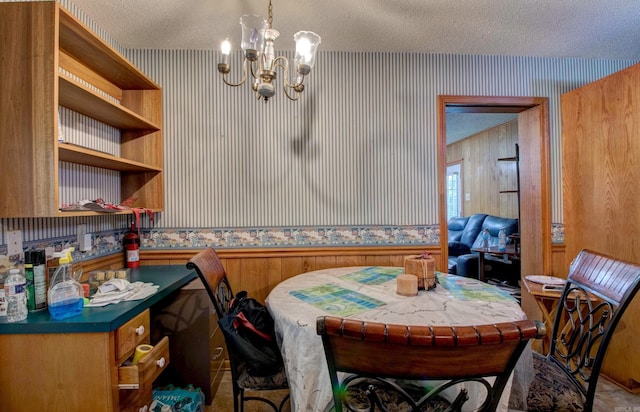 32 Bonnie Park Dr, Pine Bluff, AR 72601 - dining area with wallpapered walls, a chandelier, a textured ceiling, a wainscoted wall, and wood walls