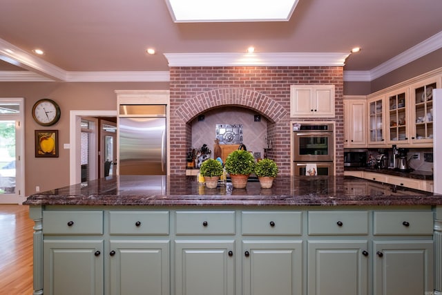 18 Chenal Cir, Little Rock, AR 72223 - kitchen featuring appliances with stainless steel finishes, a kitchen island, crown molding, green cabinetry, and decorative backsplash