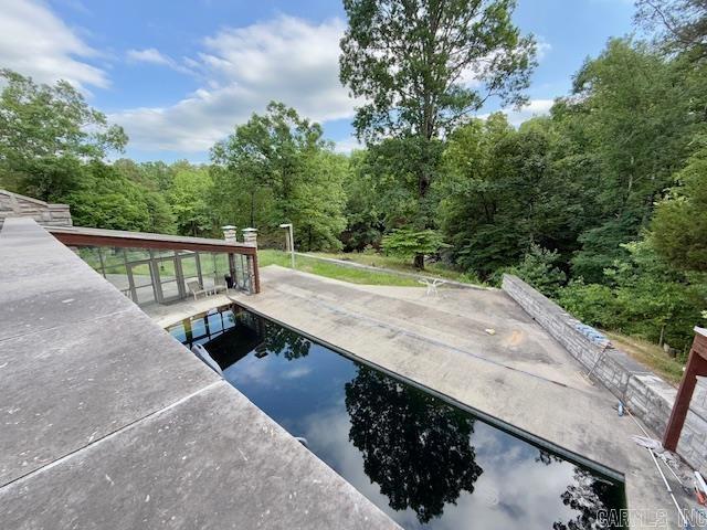 view of pool featuring a forest view