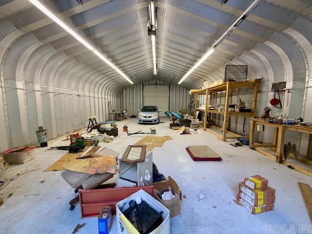 misc room with lofted ceiling and a garage