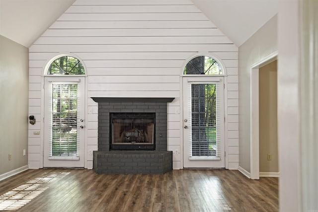 1309 Frontier, White Hall, AR 71602 - unfurnished living room with lofted ceiling, wood finished floors, a brick fireplace, and baseboards
