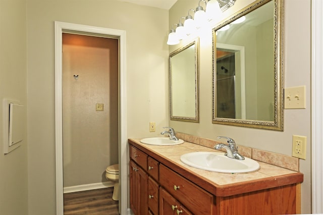 1309 Frontier, White Hall, AR 71602 - full bathroom with double vanity, toilet, and wood finished floors