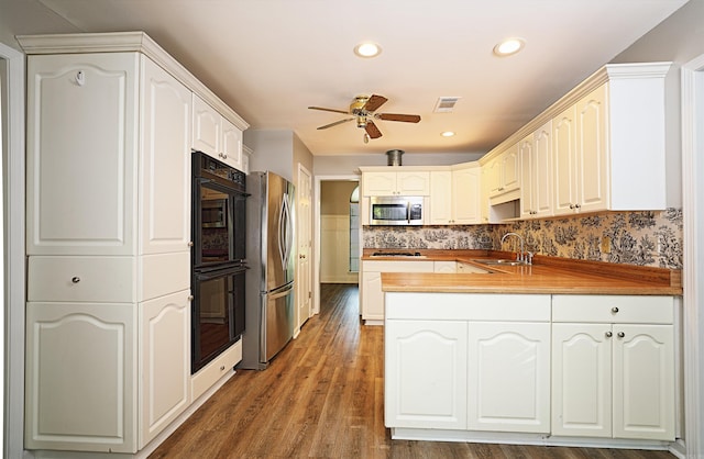 1309 Frontier, White Hall, AR 71602 - kitchen featuring appliances with stainless steel finishes, a peninsula, a sink, a ceiling fan, and wood finished floors