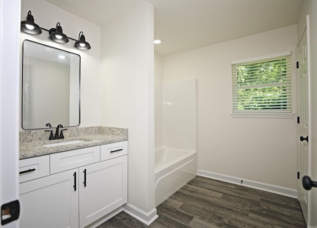 904 W Holland, White Hall, AR 71602 - bathroom with wood finished floors, vanity, baseboards, and bathing tub / shower combination