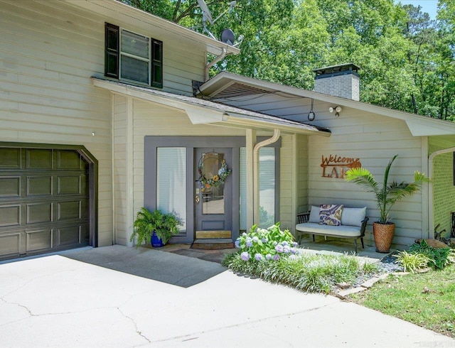 366-370 Restful Ridge Rd, Hot Springs, AR 71913 - property entrance with a chimney, concrete driveway, and an attached garage