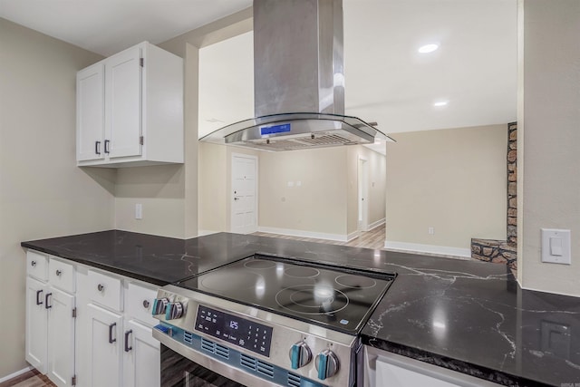 1907 Creekwood Dr, Conway, AR 72032 - kitchen featuring island exhaust hood, stainless steel electric stove, white cabinetry, and dark stone counters