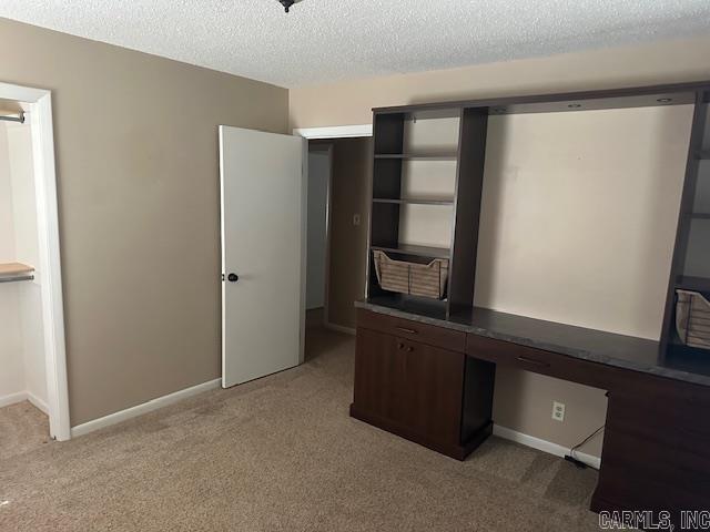 1 Rogers Dr, Morrilton, AR 72110 - unfurnished office with light colored carpet, a textured ceiling, baseboards, and built in desk