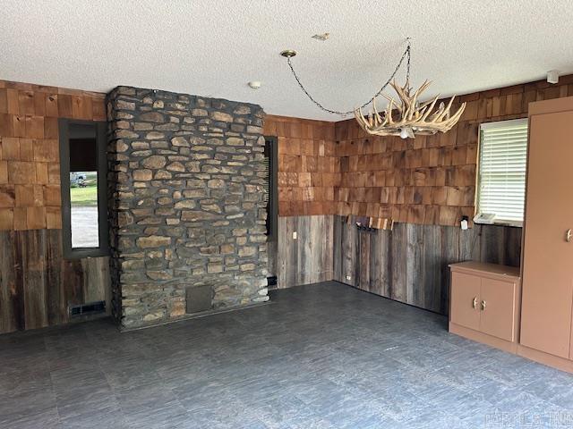 1 Rogers Dr, Morrilton, AR 72110 - unfurnished dining area featuring wood walls, a textured ceiling, and a chandelier