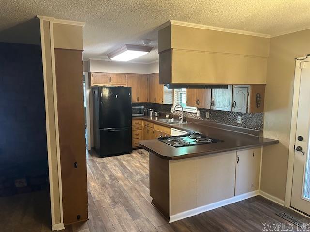 1 Rogers Dr, Morrilton, AR 72110 - kitchen featuring freestanding refrigerator, a sink, cooktop, dark countertops, and wood finished floors