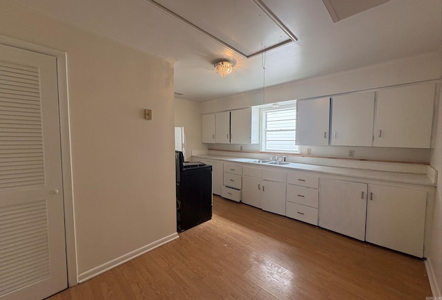 1617 Maple St, North Little Rock, AR 72114 - kitchen with black range with electric stovetop, a sink, white cabinetry, light countertops, and light wood-type flooring