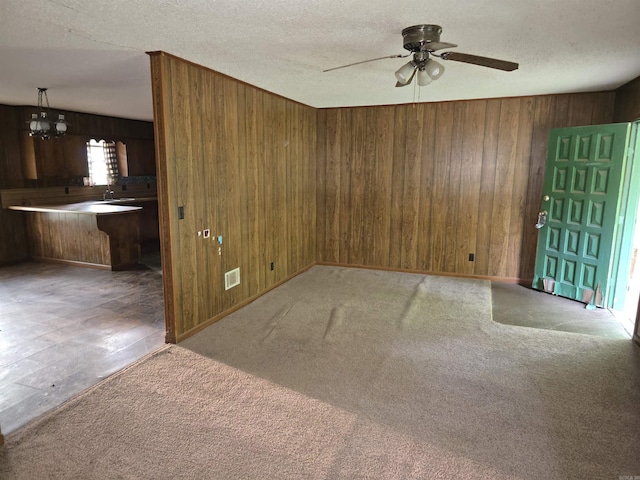 85 Bailey Rd, Morrilton, AR 72110 - empty room featuring wooden walls, a ceiling fan, a chandelier, carpet, and a textured ceiling