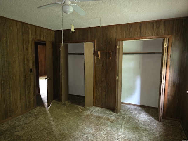 85 Bailey Rd, Morrilton, AR 72110 - unfurnished bedroom with wooden walls, carpet, a closet, a textured ceiling, and a ceiling fan