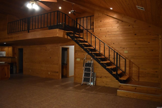 10355 Rodeo Rd, Belleville, AR 72824 - stairway featuring wooden walls, high vaulted ceiling, a ceiling fan, and wood ceiling