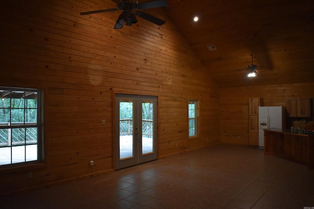 10355 Rodeo Rd, Belleville, AR 72824 - unfurnished living room with ceiling fan, high vaulted ceiling, french doors, plenty of natural light, and wooden walls