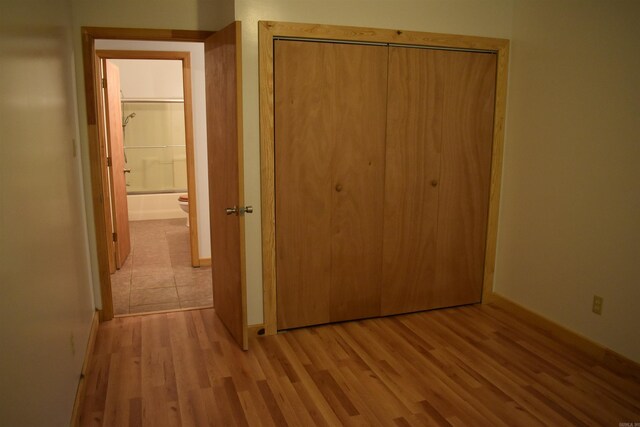 10355 Rodeo Rd, Belleville, AR 72824 - unfurnished bedroom with wood finished floors, a closet, and baseboards