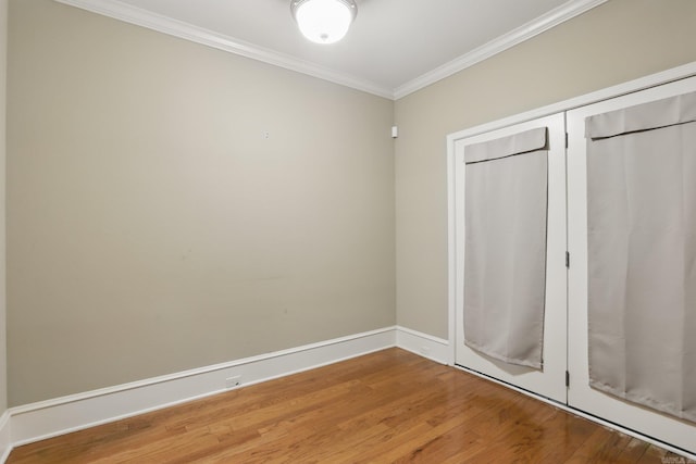 7106 Ohio St Unit 6, Little Rock, AR 72207 - unfurnished bedroom with wood finished floors, crown molding, a closet, and baseboards