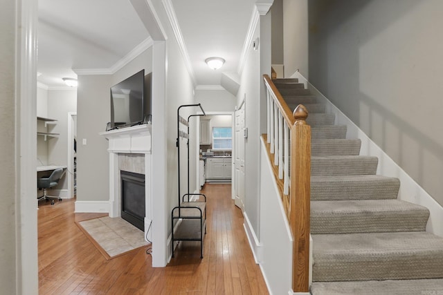 7106 Ohio St Unit 6, Little Rock, AR 72207 - stairway with ornamental molding, a tile fireplace, and hardwood / wood-style flooring
