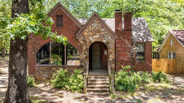 1405 Fair Park Blvd, Little Rock, AR 72204 - english style home with stone siding, a chimney, a gate, a shingled roof, and brick siding