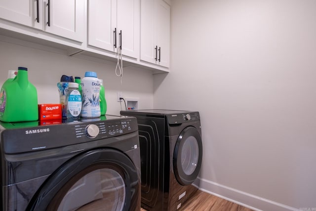 2103 Wolfe St, Little Rock, AR 72202 - laundry area with washer and clothes dryer, light wood-style floors, cabinet space, and baseboards