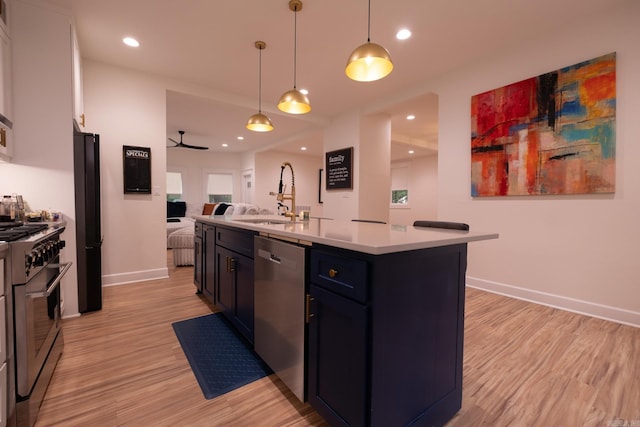 2103 Wolfe St, Little Rock, AR 72202 - kitchen featuring stainless steel appliances, a sink, open floor plan, light wood-style floors, and light countertops