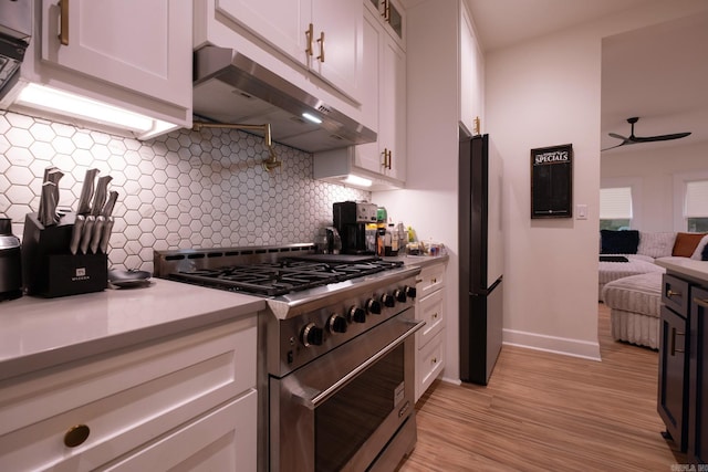 2103 Wolfe St, Little Rock, AR 72202 - kitchen featuring high end range, under cabinet range hood, freestanding refrigerator, and white cabinets