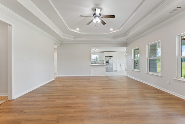 15987 E Miller Sardis Rd, Bauxite, AR 72011 - unfurnished living room featuring a tray ceiling, a ceiling fan, ornamental molding, light wood-style flooring, and baseboards