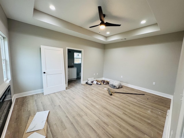 207 W Military Rd, North Little Rock, AR 72118 - unfurnished bedroom with a raised ceiling, light wood-style floors, baseboards, recessed lighting, and a ceiling fan